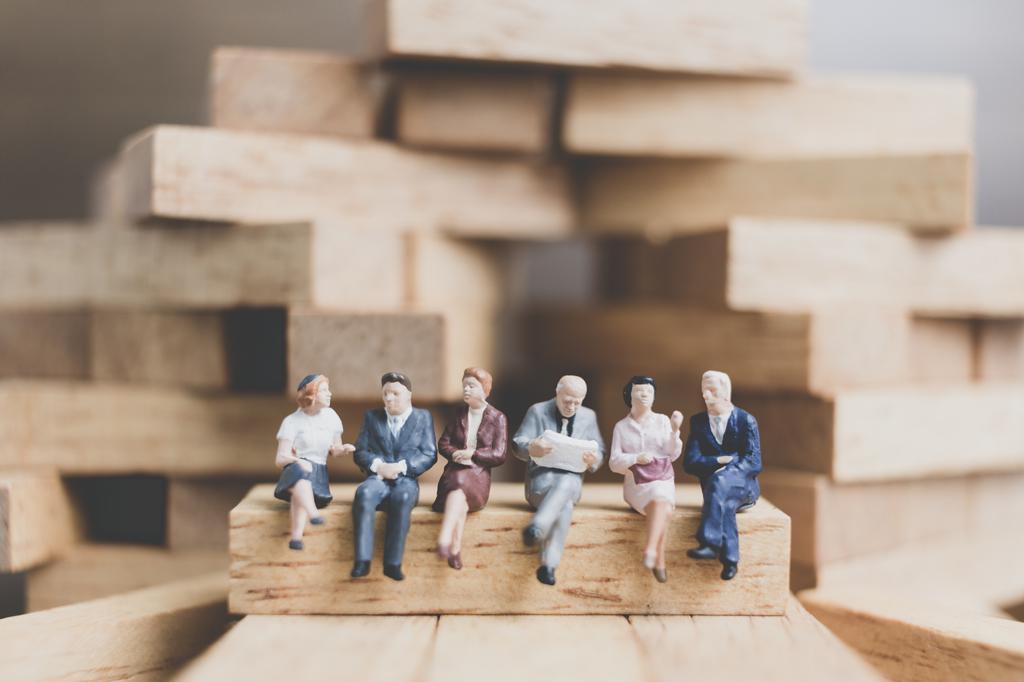 Miniature people : Business People sitting on wood block with wo