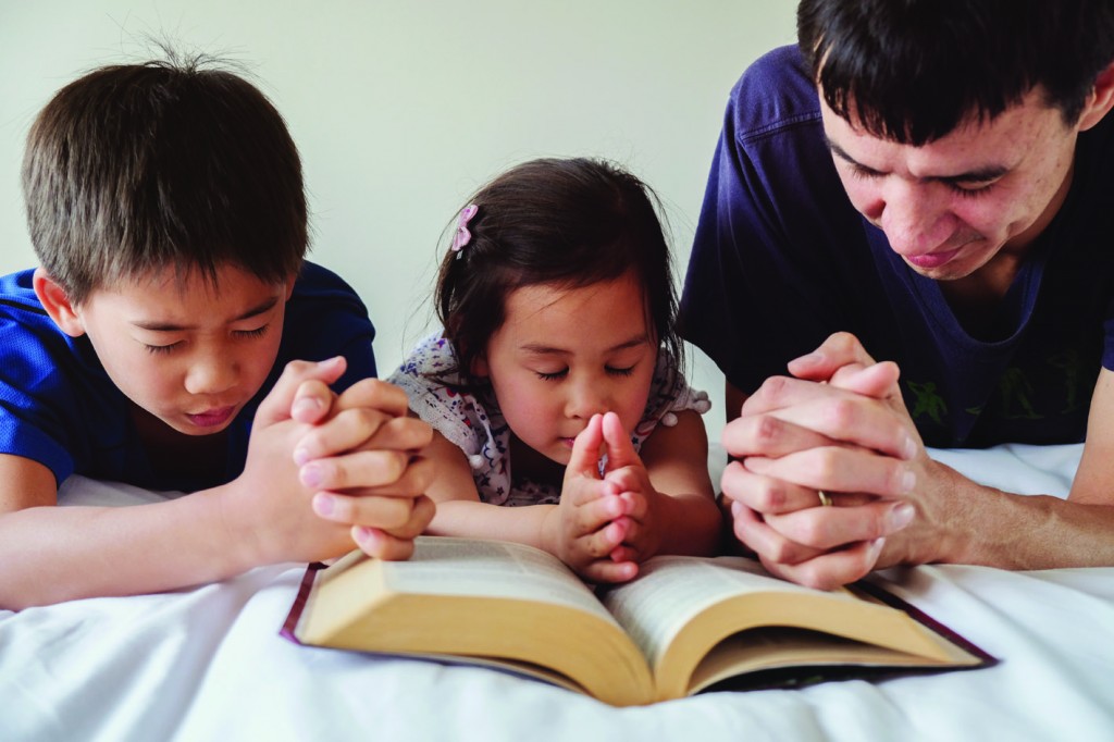 parent and childred praying on the bed, family pray together