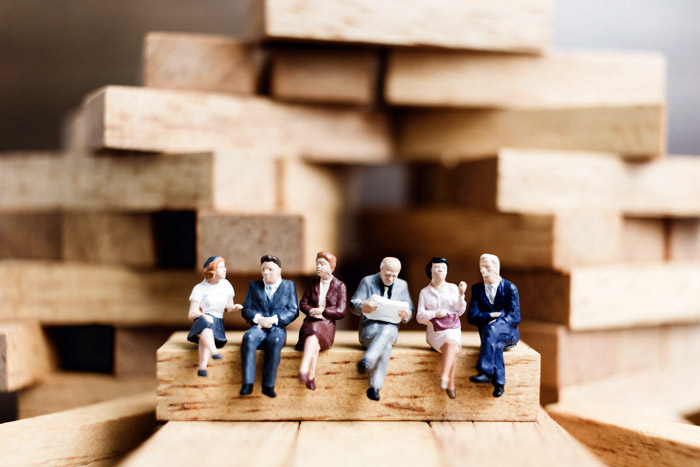 Miniature people : Business People sitting on wood block with wo