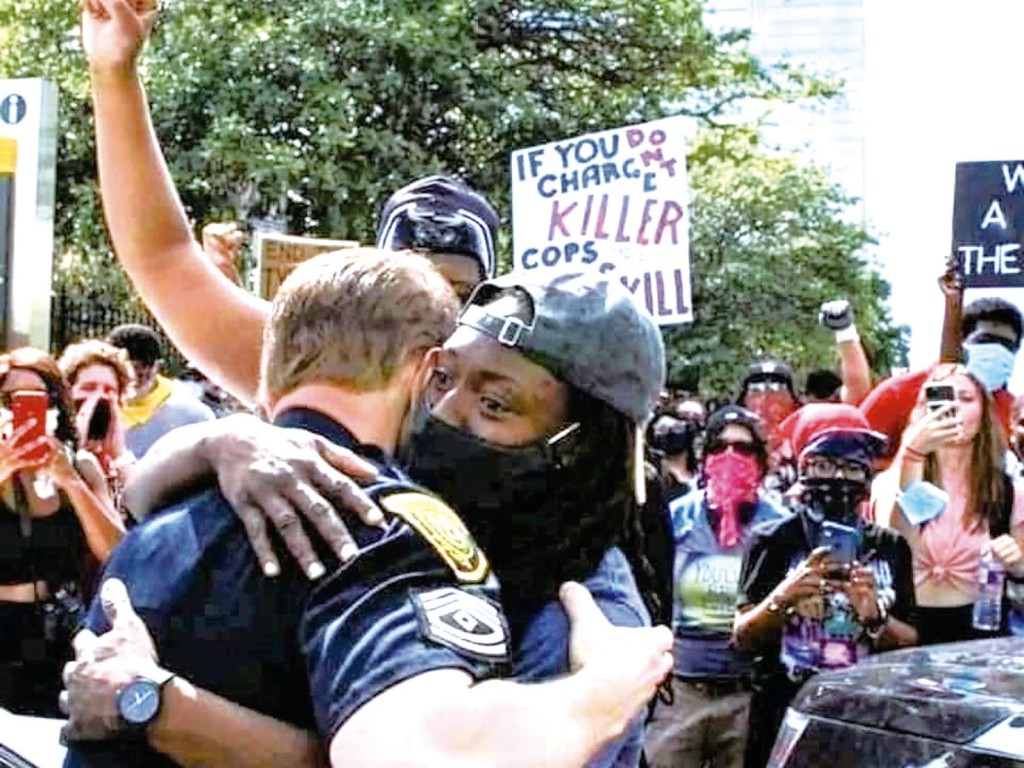 和平示威的非裔男子擁抱白人警察。（圖∕twitter@Tendencia Noticias）