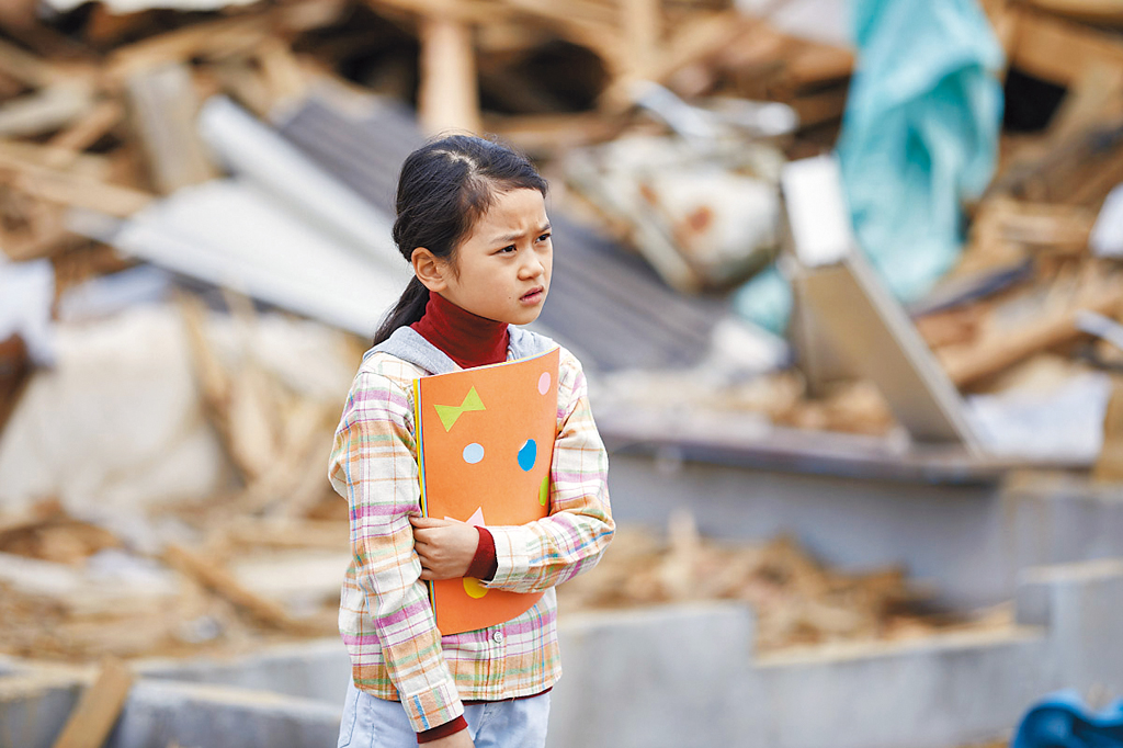 政志在311大海嘯災區，遇見希望能拍全家福的女孩。（劇照提供：采昌國際）