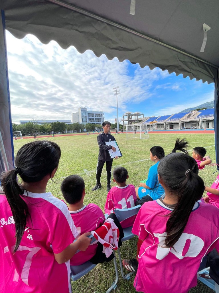 吳優協助國小學弟妹，在足球比賽過程中討論戰術