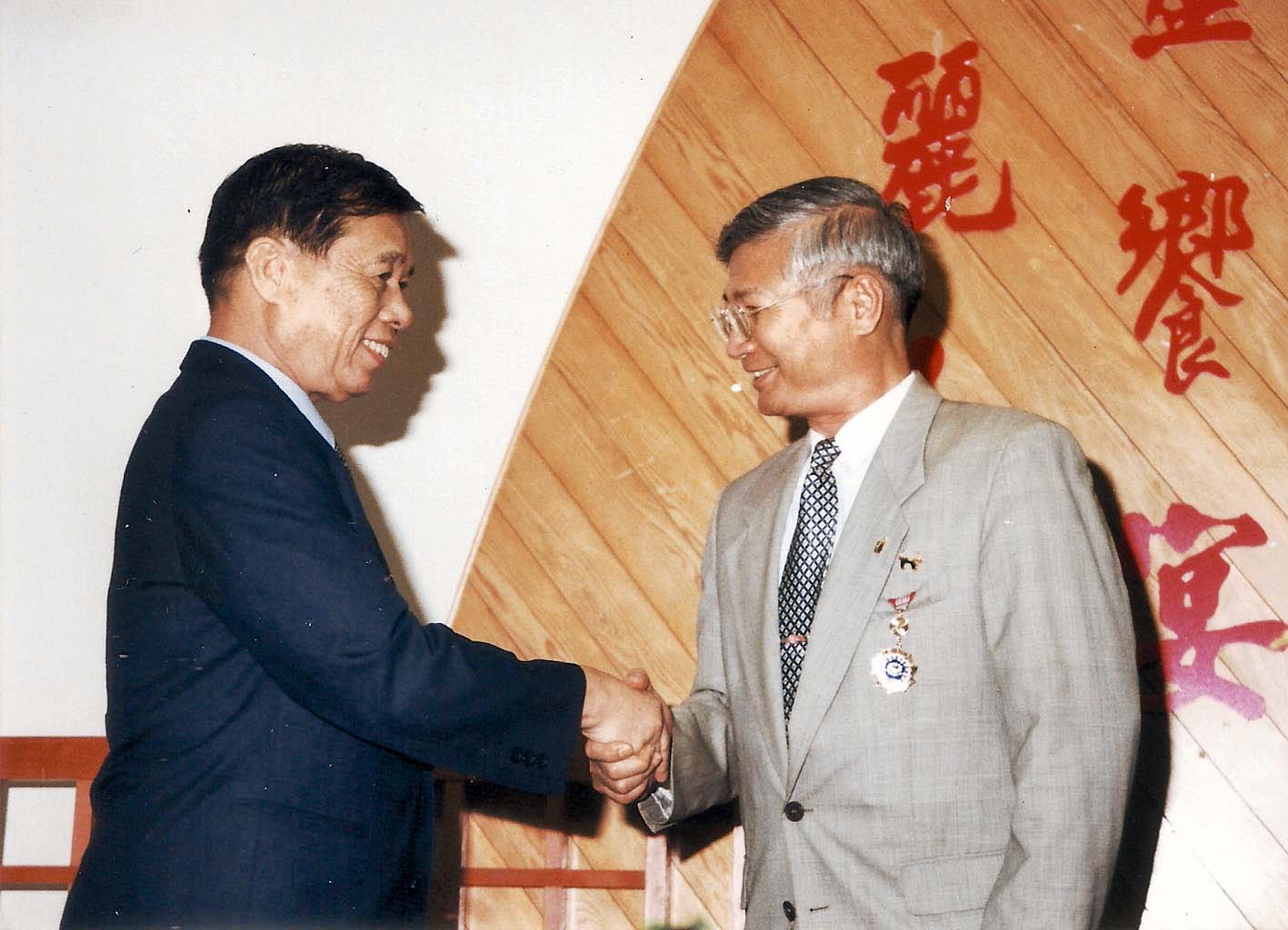 警政廳廳長王一飛（左）頒發榮譽獎章。