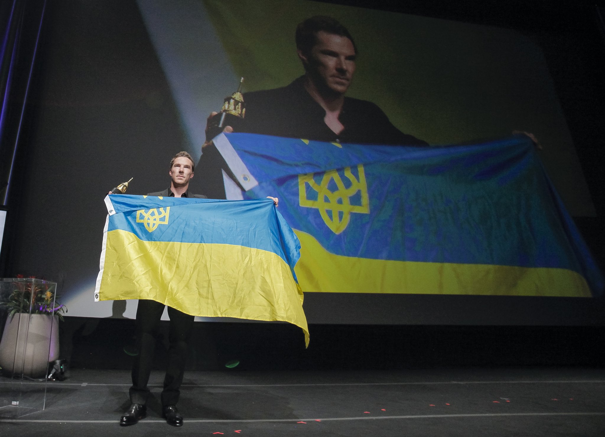 英國男星康柏拜區上台領獎時，手拿烏克蘭國旗。（圖／翻攝自Twitter@SBIFF）