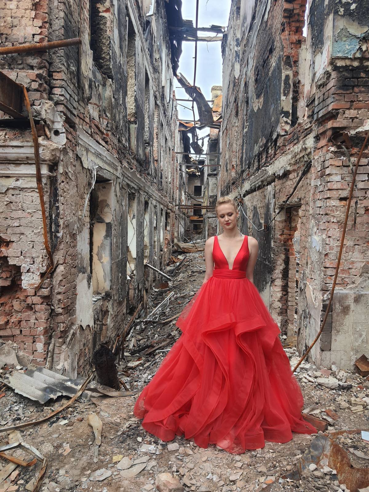 烏克蘭高中女學生穿著原本畢業典禮要穿的紅色禮服，回到已成廢墟的母校拍畢業照，令人不勝唏噓。（圖／翻攝自Twitter@MFA_Ukraine）