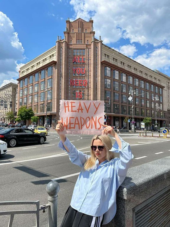 女孩手拿標語希望世界各國提供烏克蘭更多武器對抗俄羅斯。（Twitter@Wh0Know5）