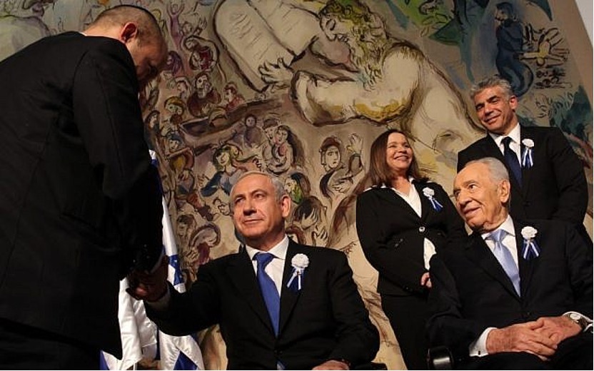 2013年2月，在時任總統的西蒙．佩雷斯（Shimon Peres）的注視下，前總理班傑明．納坦雅胡（圖中）在國會開幕式上，與猶太人家園黨領導人納夫塔利．班奈特握手。在他們身後是工黨的雪莉．雅奇莫維奇和未來黨的亞伊爾．拉皮德。（照片來源：Nati Shohat/Flash90）