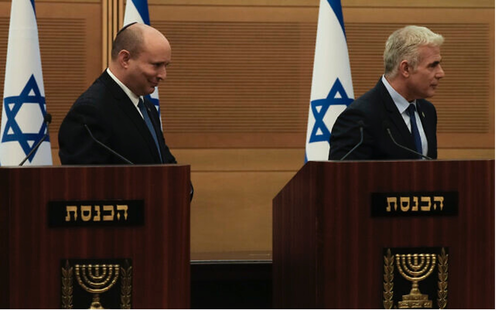 2022年6月20日（星期一）以色列總理納夫塔利．班奈特（圖左）和外交部長亞伊爾．拉皮德在以色列國會發表聯合聲明後離開講台，當日宣佈他們的聯合政府即將解散。（照片來源：Maya Alleruzzo/美聯社）