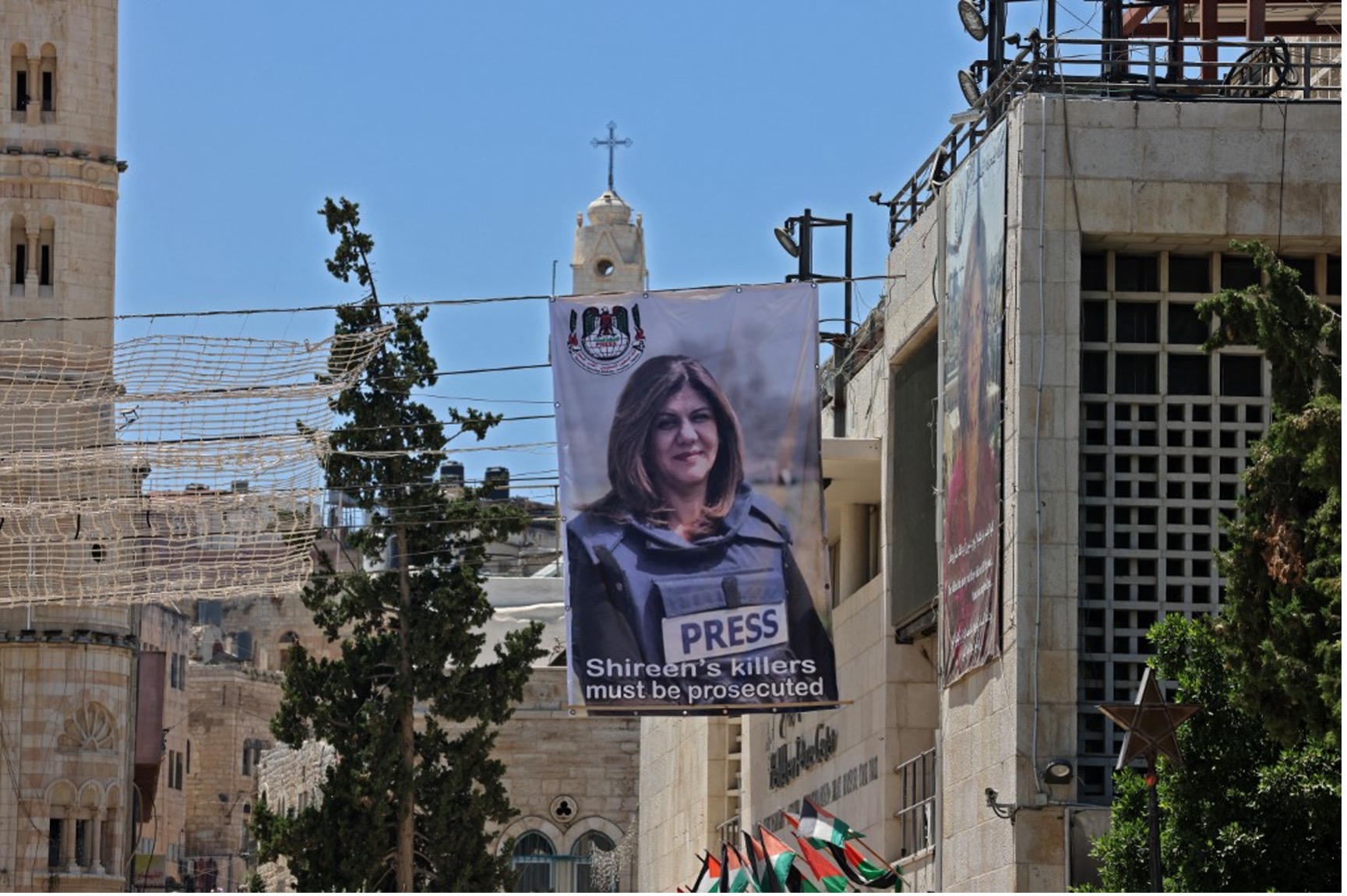 2022年7月14日，描繪被殺的巴勒斯坦裔美國記者夏琳．阿布．阿克勒的橫幅懸掛在俯瞰約旦河西岸伯利恆聖誕教堂（Church of the Nativity）的建築物上照片來源：Ahmad GHARABLI/AFP；耶路撒冷全球華人敬拜中心/提供