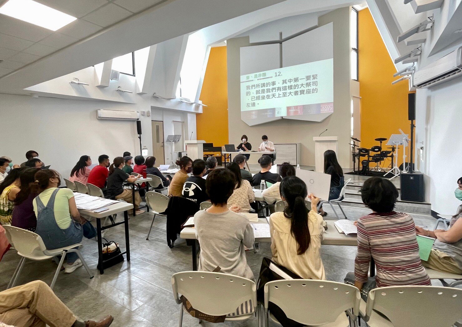 二樓聚會的會堂背景是黃色，挑高區東、南、西三面間接採光，達到充足的自然採光。