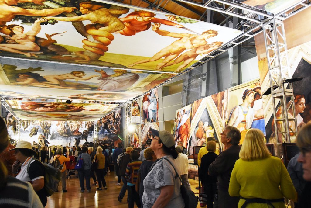 遊客在展覽中仔細欣賞壁畫的各個細節。（圖／翻攝自chapelsistine.com）