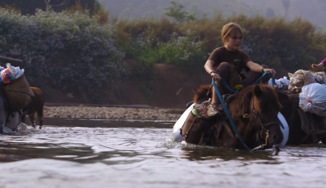 凱倫的兒子騎馬渡過湍急的河流。（圖／YouTube@DEIDOX Films截圖）
