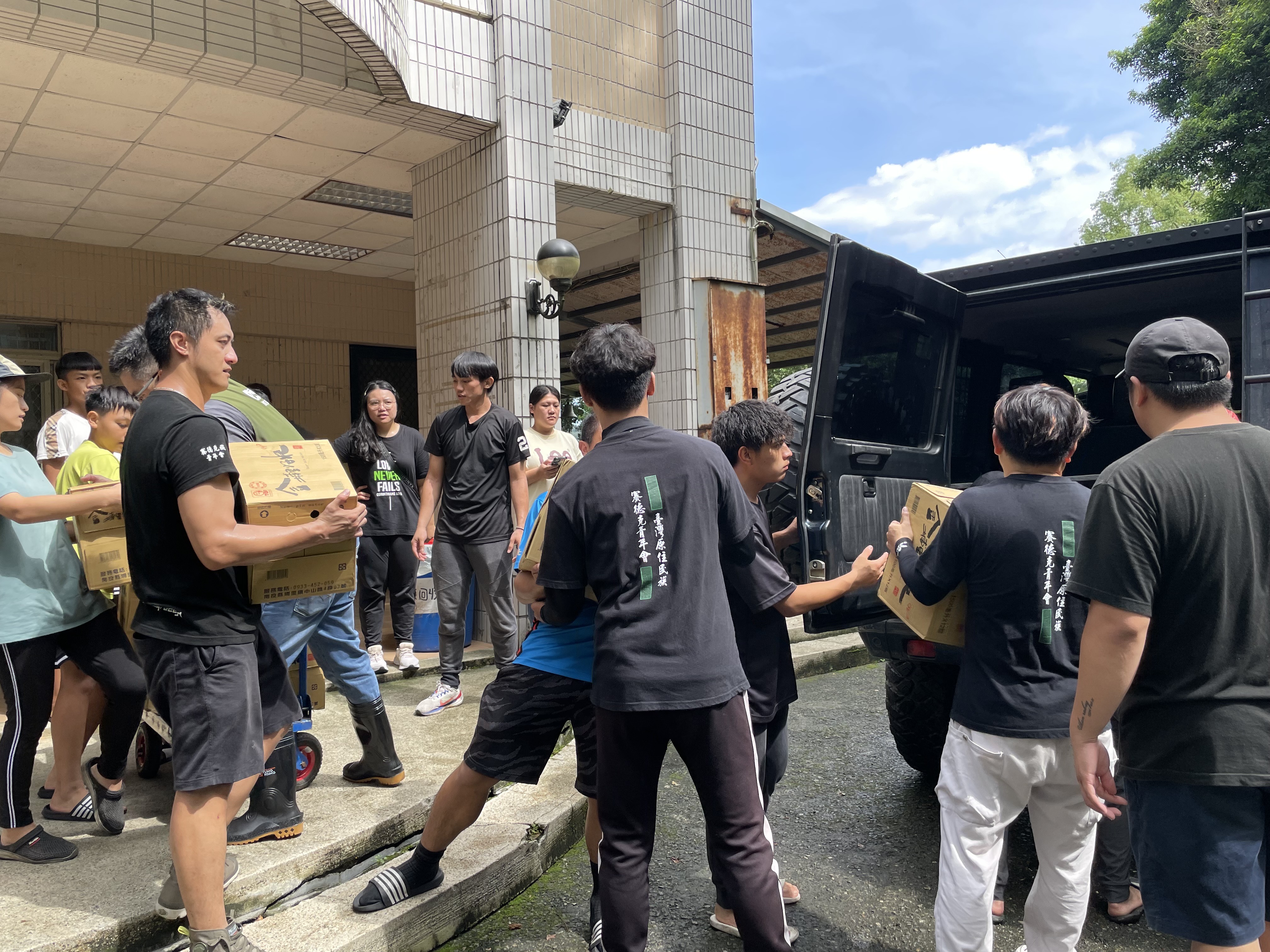 青年搬運物資到車上。(圖/李容珍攝影)