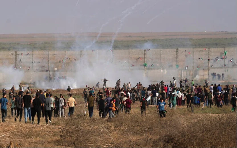 2023年8月21日，加薩以東的以色列邊境，巴勒斯坦抗議者與以色列軍隊發生衝突時，抗議者奔跑躲避催淚瓦斯。（照片來源：AP Photo/Adel Hana）