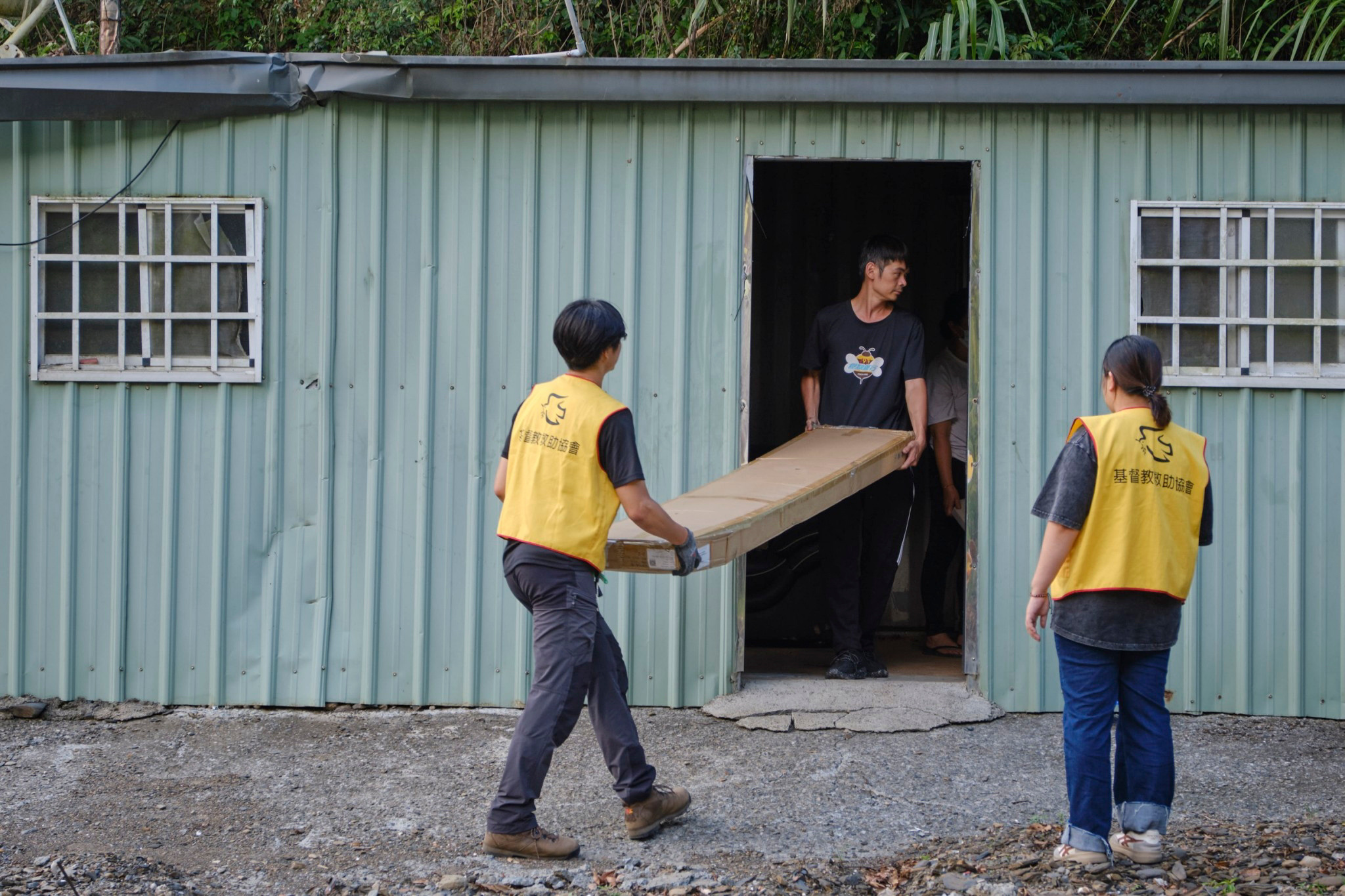 救助協會志工徒手搬運大型家具助受災戶重整家園。