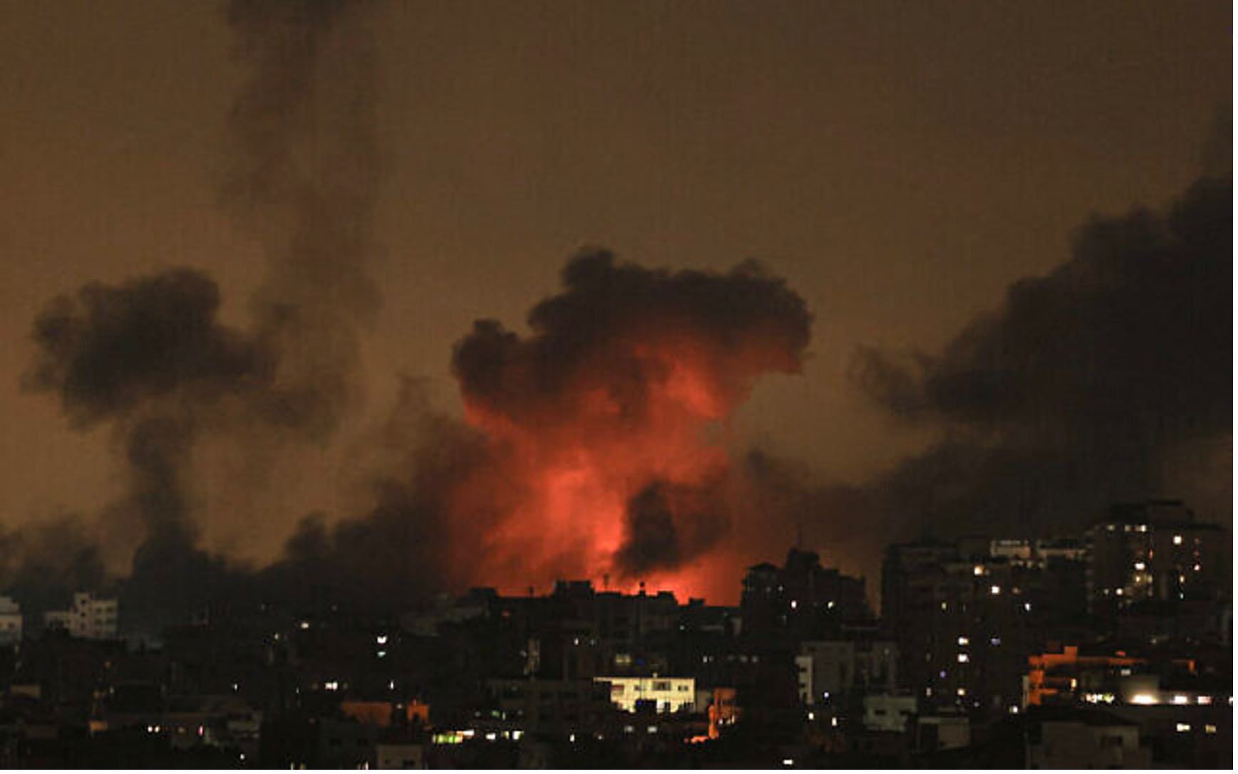 2023年10月10日，以色列空襲加薩時，爆炸的火光照亮了天空。（照片來源：MAHMUD HAMS/AFP）