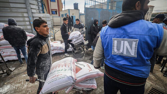 2024年1月28日，流離失所的巴勒斯坦人在加薩地帶南部拉法（Rafah）的聯合國巴勒斯坦難民救濟和工程署（UNRWA）中心領取糧食援助。（照片來源：AFP）