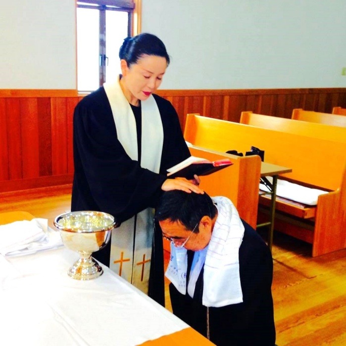 廣瀨香織牧師為會友施洗。（圖／翻攝自新居濱教會臉書）