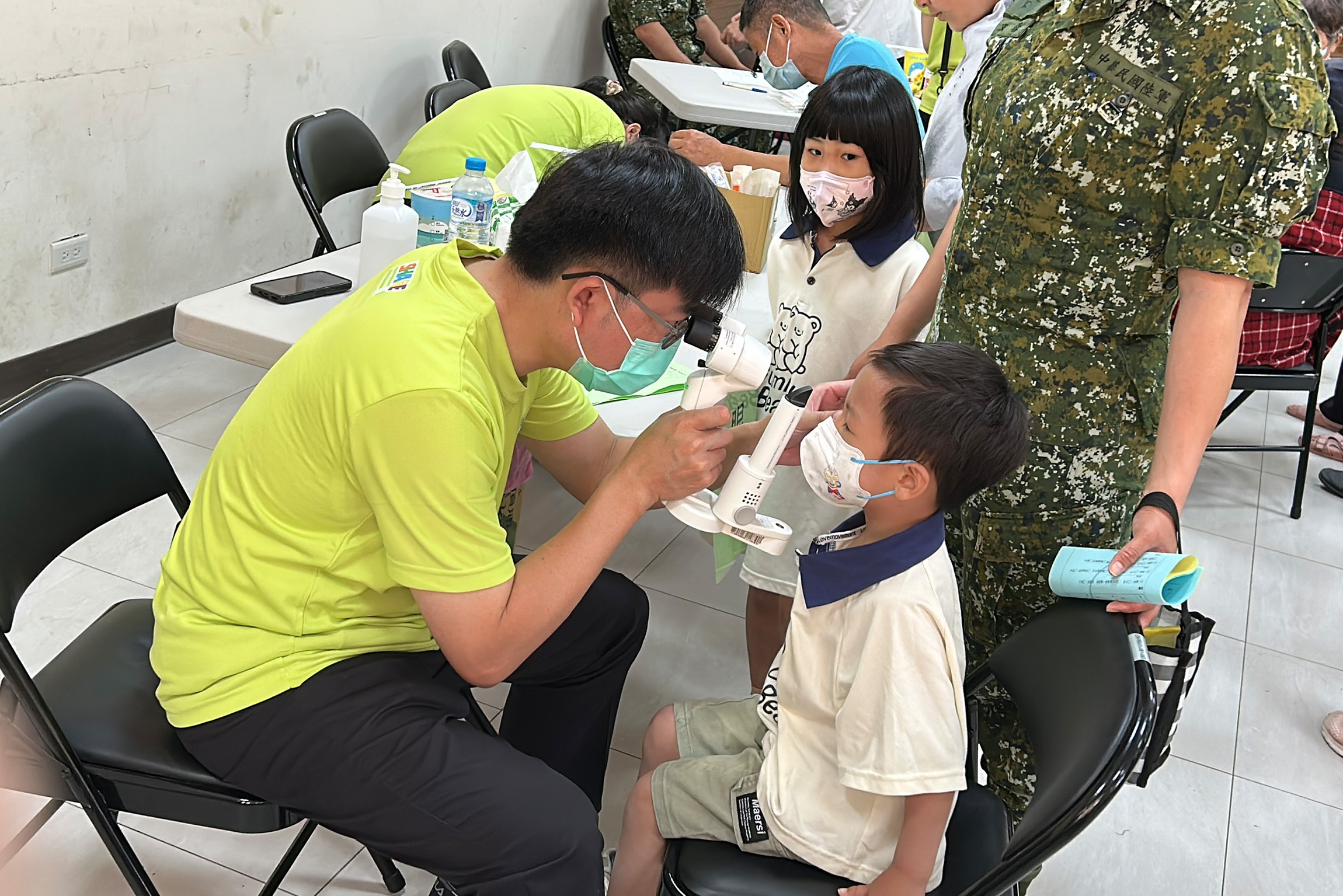 眼科部副主任吳建昇醫師為軍眷子女進行眼睛檢查。(彰基提供)