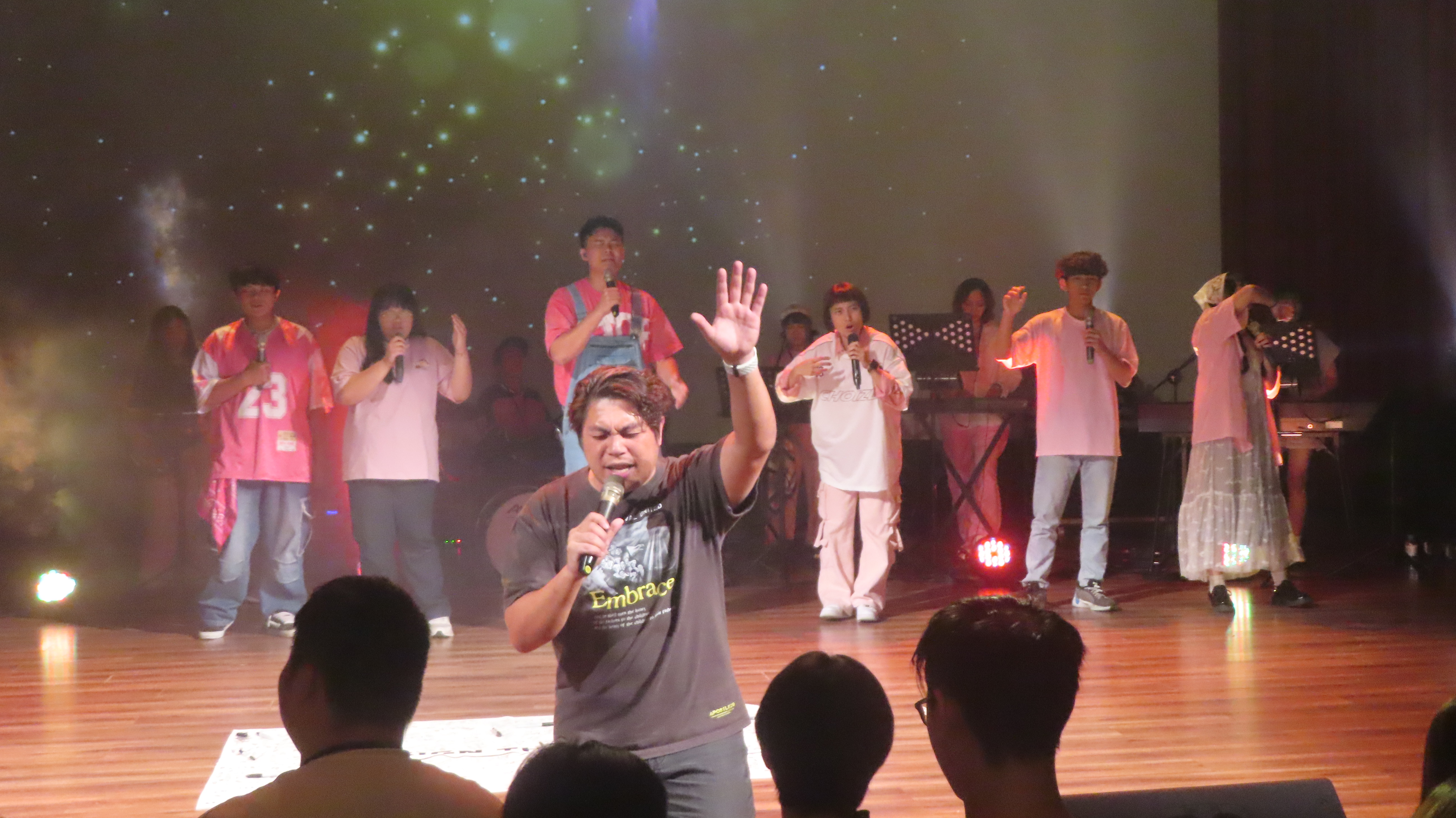 蘇雅各牧師屈膝帶領年輕人為校園復興禱告。（圖/梁敬彥攝影）