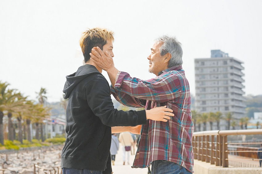 當雄太焦急的找到迷路的父親，父親只是捧起他的臉說：「Smile, son.」。（劇照提供：采昌國際）