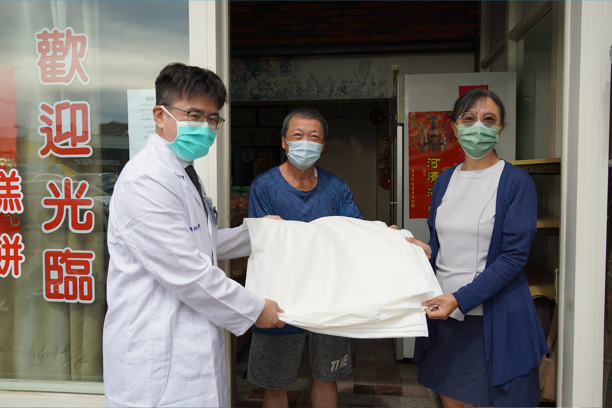 永安二路住戶永安二路經營麵包店的張先生（中）感謝鹿基致贈「科技沙包」。(彰基提供)