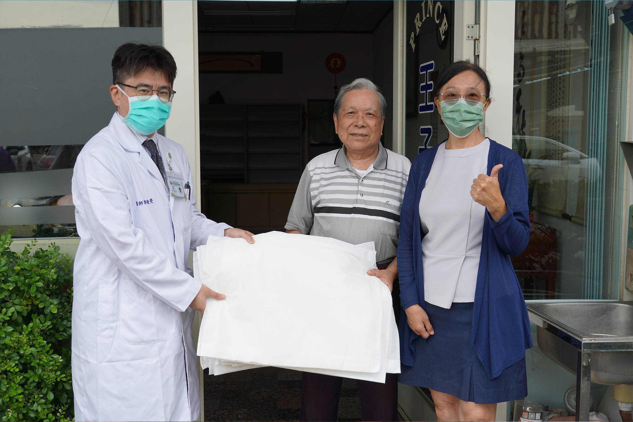 鹿基副院長郭浚熒（左一）、馬潔儀（右一）共同致贈永安二路許先生（中）「科技沙包」。(彰基提供)