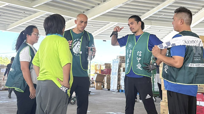 秀林鄉鄉長（左二背對鏡頭，穿綠色衣服)前來協助，主顧兒•巴弄牧師（左三）等人說明物資整理情況。（受訪者提供）