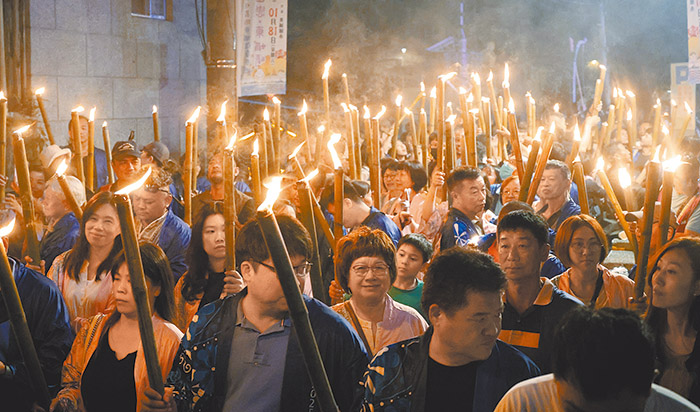 手持火把部落巡禮報佳音。(翻攝巨人設計公司臉書)