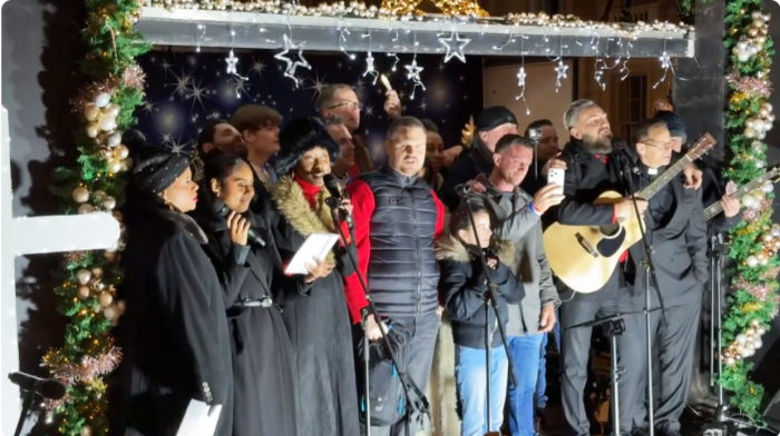 湯米.羅賓遜(前排右三)上台分享見證並自拍。(YouTube@UKSploosh截圖)