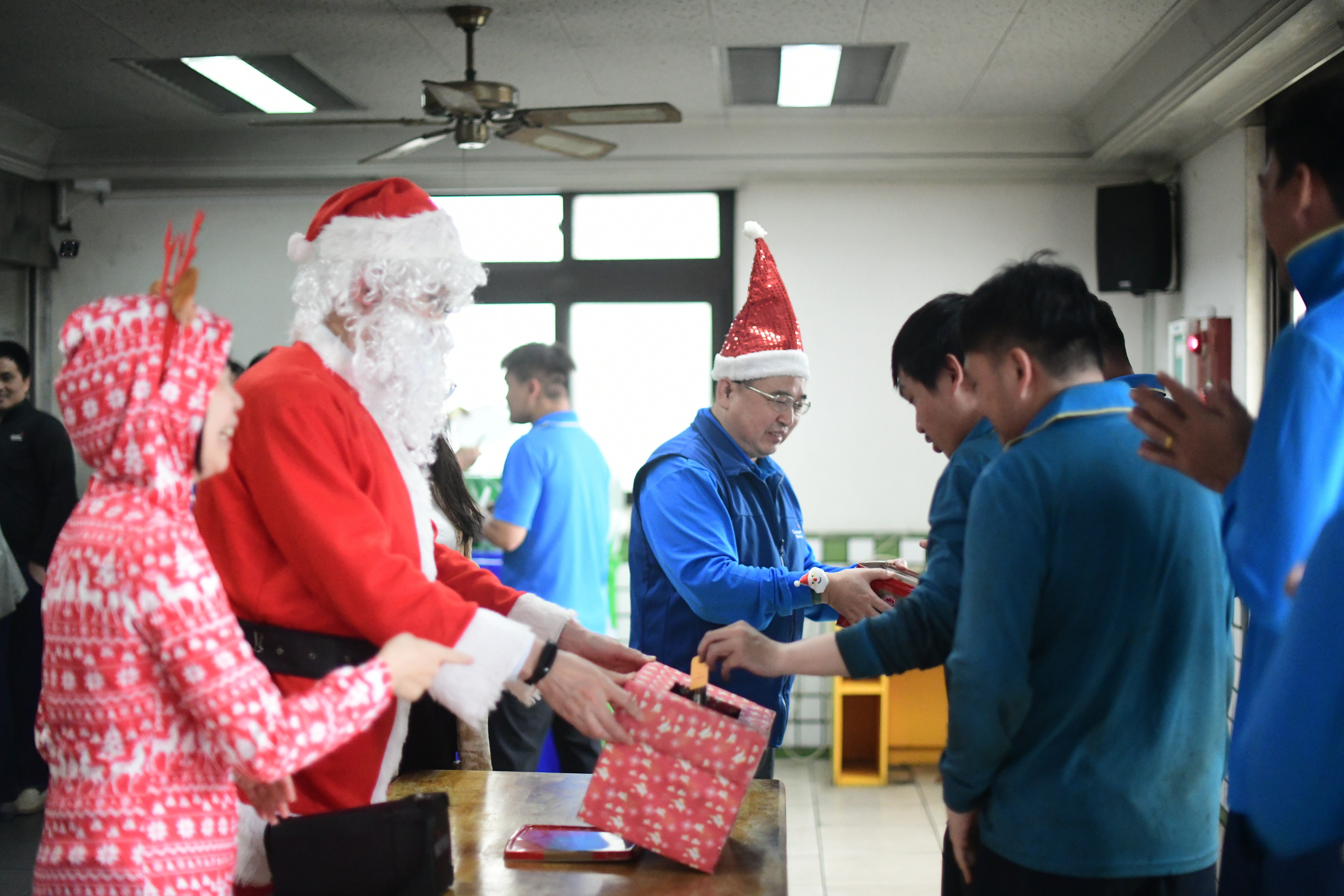 陳偉望扮演聖誕老公公(左二)讓員工抽聖經卡片禮物。（圖／永光化學提供）