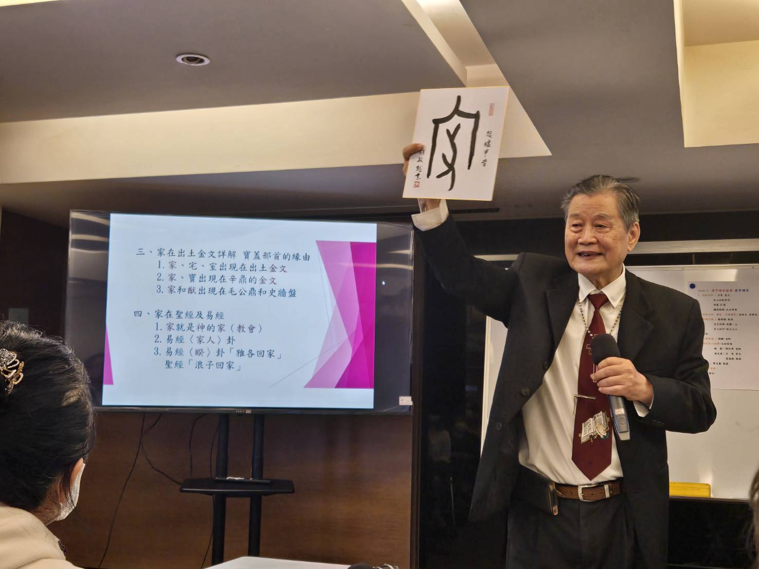 戴維揚院長高舉用金文書寫的家字，說明漢字與聖經典故。（圖/梁敬彥攝影）