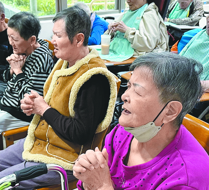 來到萬里仁家福音堂的長者虔誠祈禱。(圖/受訪者提供)