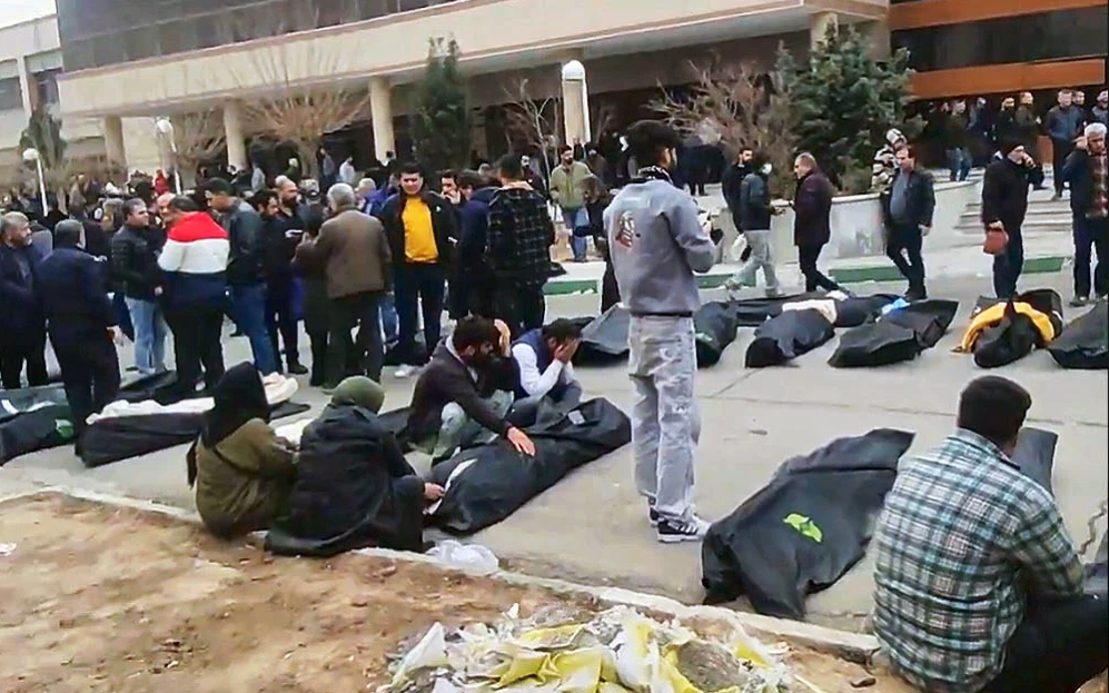 這張畫面截圖來自2026年1月9日至11日期間在社群媒體流傳的影片。據報這是在伊朗首都德黑蘭省卡赫里扎克（Kahrizak）郊區鎮壓行動後，一座堆滿遺體的停屍間與外部，許多人在旁哀悼。（照片來源：UGC via AP）