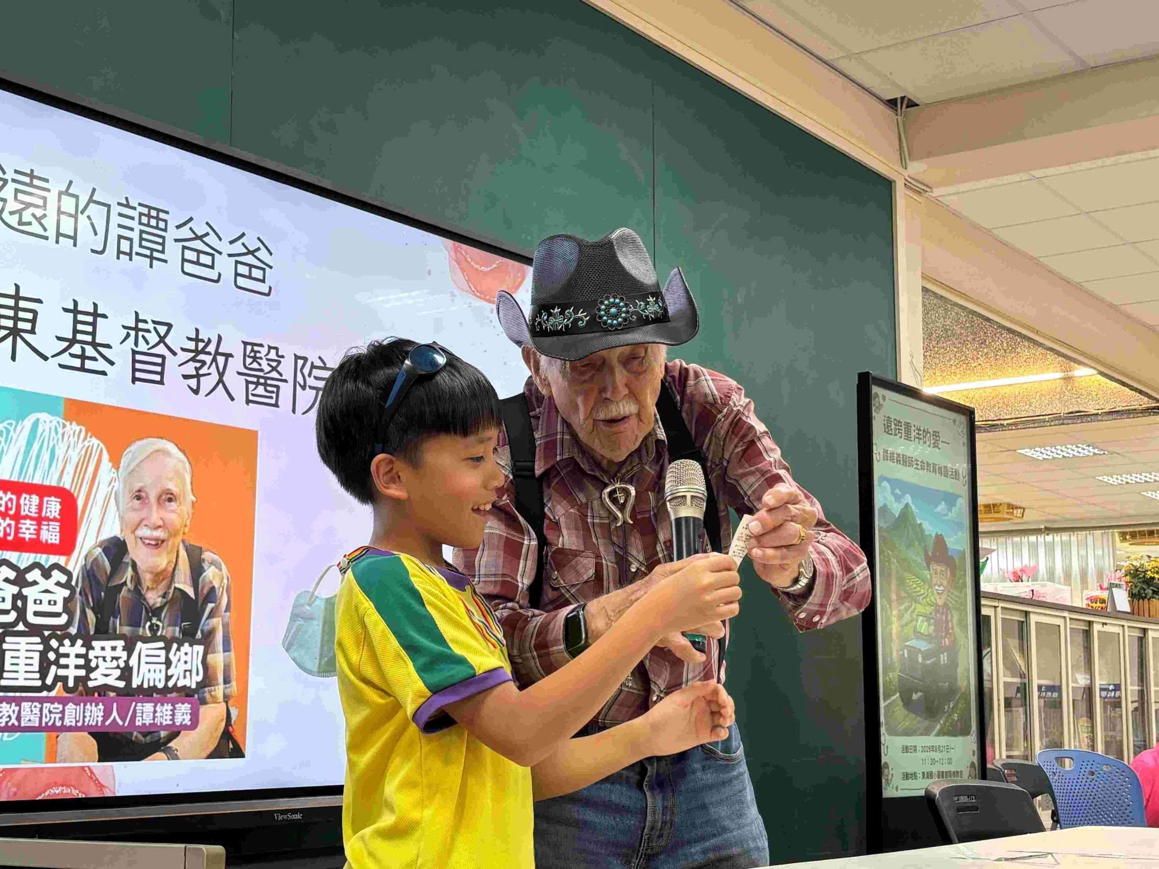 台東基督教醫院創院院長譚維義宣教士邀請東海國小學生上台製作紙蜻蜓。(東基提供)